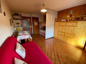 een woonkamer met een rode bank en een tafel bij Appartement Le Grand-Bornand, 1 pièce, 4 personnes - FR-1-241-239 in Le Grand-Bornand