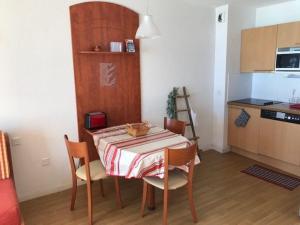 ラ・モンジーにあるAppartement cosy 4 pers. avec terrasse, piscine, fitness et parking - À 300m des pistes - FR-1-404-336の部屋にテーブルと椅子のあるキッチン