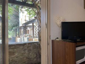 a living room with a flat screen tv next to a door at Appartement Cerbère, 19 pièces, 4 personnes - FR-1-225C-97 in Cerbère