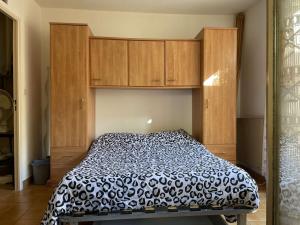 a bedroom with a bed with wooden cabinets at Appartement Cerbère, 19 pièces, 4 personnes - FR-1-225C-97 in Cerbère