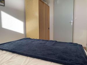 - un lit avec une couverture bleue dans l'établissement Appartement Saint-Hilaire-de-Riez, 2 pièces, 4 personnes - FR-1-224-784, à Saint-Hilaire-de-Riez