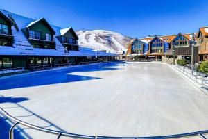 an ice skating rink in a town with snow covered buildings at Mountain Village Lodge 351 in Park City