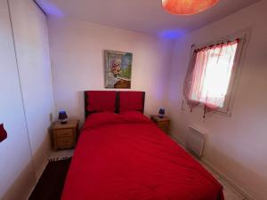 Cama roja en una habitación pequeña con ventana en Appartement Vieux-Boucau-les-Bains, 3 pièces, 6 personnes - FR-1-379-142, en Vieux-Boucau-les-Bains
