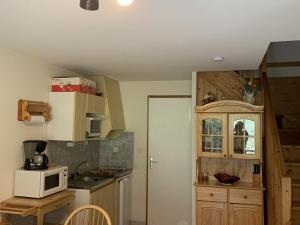 a kitchen with wooden cabinets and a white microwave at Appartement Saint-Jean-d'Aulps, 2 pièces, 6 personnes - FR-1-573-58 in Saint-Jean-d'Aulps