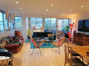 a living room with a couch and tables and chairs at Le Paul Chandon Centre-ville 4 pers Parking privé 2 places in Épernay