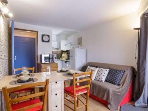 cocina pequeña con mesa, sillas y sofá en Appartement Saint-Lary-Soulan, 2 pièces, 4 personnes - FR-1-296-383, en Saint-Lary-Soulan