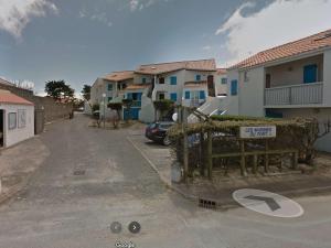 Appartement Noirmoutier-en-l'Île, 2 pièces, 4 personnes - FR-1-224B-150 في نوارموتيير أون ليل: شارع فيه بيوت وسياره تقف في ممر