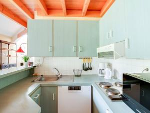una cocina con armarios azules y fregadero en Appartement La Mongie, 3 pièces, 8 personnes - FR-1-404-337, en Bagnères-de-Bigorre