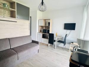 a living room with a couch and a table at Studio Églantine à Cambo-les-Bains, proche thermes, terrasse, parking, accès Internet, animaux OK - FR-1-495-106 in Cambo-les-Bains