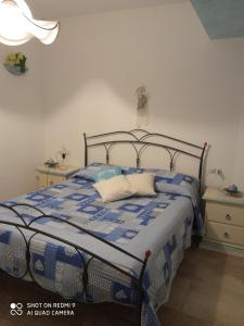 a bedroom with a bed with a blue and white comforter at Villa Baia Sant Anna in Tanaunella