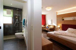 Habitación de hotel con baño y dormitorio en Gästehaus Steinerhof en Nikolsdorf