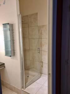 W łazience znajduje się prysznic ze szklanymi drzwiami. w obiekcie Suite indépendante avec 1 chambre et 1 bureau w Montpellier