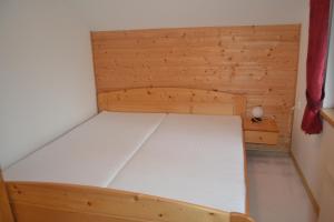 a small wooden bed in a small room at Chata Dolce in Trutnov
