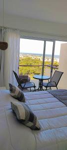 a bedroom with two beds and a table and chairs at Terrazas de la Viuda in Punta Del Diablo