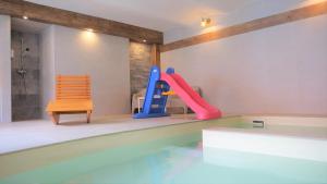 a house with a swimming pool with a slide and chairs at Babyhotel Karolínka, wellness in Vranov nad Dyjí