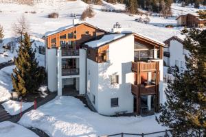 a house in the winter with snow on the ground at Casa Collina 5i-02 in Flims