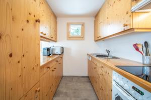 a kitchen with wooden cabinets and a sink at Casa Collina 5i-02 in Flims