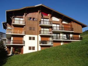 un edificio in cima a una collina erbosa di Charmant duplex rénové, 34 m², 4 pers, vue Mont Charvin - FR-1-505-25 a Notre-Dame-de-Bellecombe