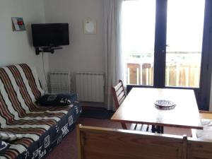 een woonkamer met een bank en een tafel bij Appartement Les Adrets-Prapoutel, 2 pièces, 5 personnes - FR-1-557-66 in Les Adrets