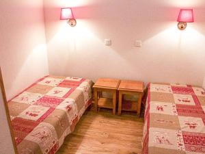 Cette chambre comprend 2 lits et une table. dans l'établissement Appartement Les Orres, 2 pièces, 6 personnes - FR-1-322-330, aux Orres