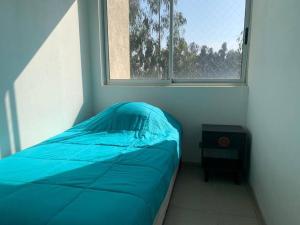 Cama pequeña en habitación con ventana en Depto Costa Algarrobo Norte, en Yeco