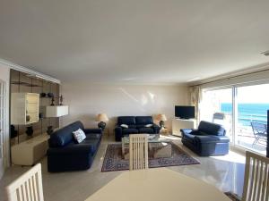 a living room with blue couches and a view of the ocean at Quiberon - Grand 2 pièces avec balcon et parking, face à la plage - FR-1-478-4 in Quiberon