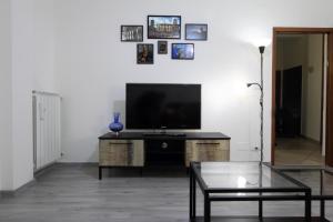 uma sala de estar com uma televisão e uma mesa de centro em Nonna Maria Guest House em Arezzo