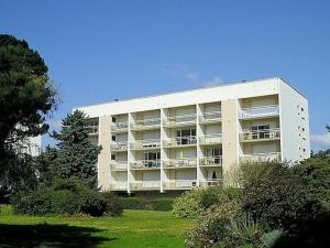 um grande edifício branco com varandas num parque em Appartement Carnac, 3 pièces, 5 personnes - FR-1-477-30 em Carnac