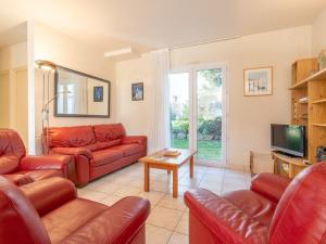 een woonkamer met rode leren banken en een televisie bij Villa Carnac, 5 pièces, 8 personnes - FR-1-477-50 in Carnac