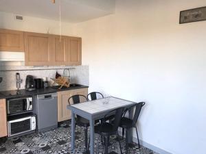 une petite cuisine avec une table et des chaises. dans l'établissement Villa T2, 4 pers, face à la mer, terrasse, parking privé, à 400m des commerces, plage devant! - FR-1-81-462, à Port-Leucate