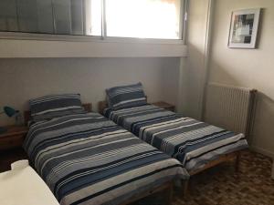 two beds in a room with a window at Appartement Argelès-sur-Mer, 3 pièces, 6 personnes - FR-1-388-167 in Argelès-sur-Mer