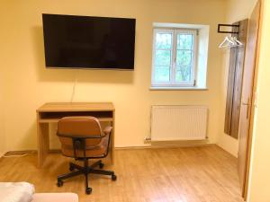 Zimmer mit einem Schreibtisch, einem Stuhl und einem TV in der Unterkunft Hoellerhof in Sankt Marien