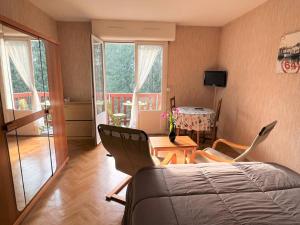1 dormitorio con cama, sillas y mesa en Charmant T1 Bis à Cambo-les-Bains avec balcon, ascenseur et parking - FR-1-495-31, en Cambo-les-Bains