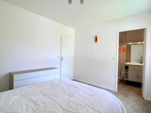 ein weißes Schlafzimmer mit einem Bett und einem Badezimmer in der Unterkunft Appartement 2 pers. RDC à Cambo-les-Bains avec Internet et Animaux admis - FR-1-495-62 in Cambo-les-Bains