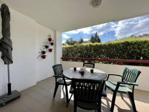 eine Terrasse mit Tisch und Stühlen und einem Fenster in der Unterkunft Appartement 2 pers. RDC à Cambo-les-Bains avec Internet et Animaux admis - FR-1-495-62 in Cambo-les-Bains + 10 Fotos