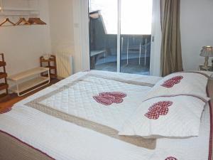 a bed with a white comforter with hearts on it at Appartement Les Orres, 2 pièces, 8 personnes - FR-1-322-355 in Les Orres