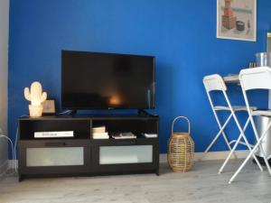 a entertainment center with a flat screen tv on a blue wall at Appart T2 avec terrasse, parking, WIFI, animaux admis - FR-1-225C-31 in Banyuls-sur-Mer