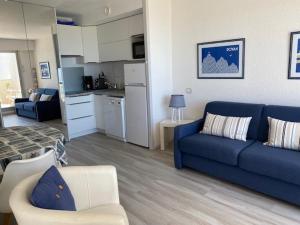sala de estar con sofá azul y cocina en Appartement Royan, 2 pièces, 4 personnes - FR-1-494-33, en Royan
