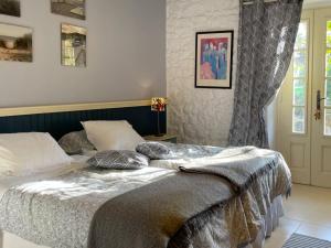 Un dormitorio con una cama con almohadas. en La Lande, en Bricquebec