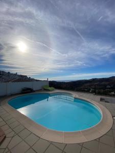 a large blue swimming pool on top of a building at Casa LUNA in Frigiliana