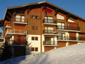 an apartment building with snow in front of it at Studio calme avec terrasse jardin et parking - 4 pers. - FR-1-505-11 in Notre-Dame-de-Bellecombe +12 photos
