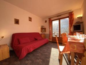 阿爾利河畔普拉茲的住宿－Appartement Praz-sur-Arly, 1 pièce, 4 personnes - FR-1-603-31，一间卧室配有红色的床和一张桌子