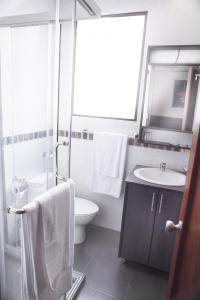 a white bathroom with a sink and a toilet at Hostal Casa de Lidice in Cuenca +27 photos