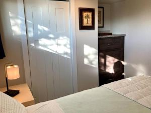 a bedroom with a bed and a dresser with a lamp at Cozy Tiny Home in the Hills in Fischer