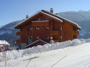 a large wooden building with snow in front of it at Charmant 3 pièces avec terrasse, stationnement, animaux acceptés à Méribel - FR-1-411-620 in Les Allues