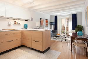 a kitchen with wooden cabinets and a table in a room at Click&Flat Stylish Torrijos in Barcelona