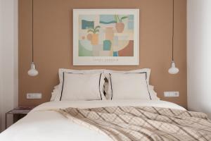 ein Schlafzimmer mit einem Bett mit einem Bild an der Wand in der Unterkunft Click&Flat Stylish Torrijos in Barcelona