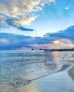 a beach with a cloudy sky and the ocean at B&B La Strea in Porto Cesareo