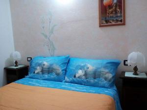 una camera da letto con letto e cuscini blu di Il Ciliegio di Lurisia a Lurisia