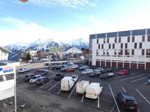 a parking lot with cars parked in front of a building at Appartement Saint-Lary-Soulan, 2 pièces, 6 personnes - FR-1-457-280 in Saint-Lary-Soulan